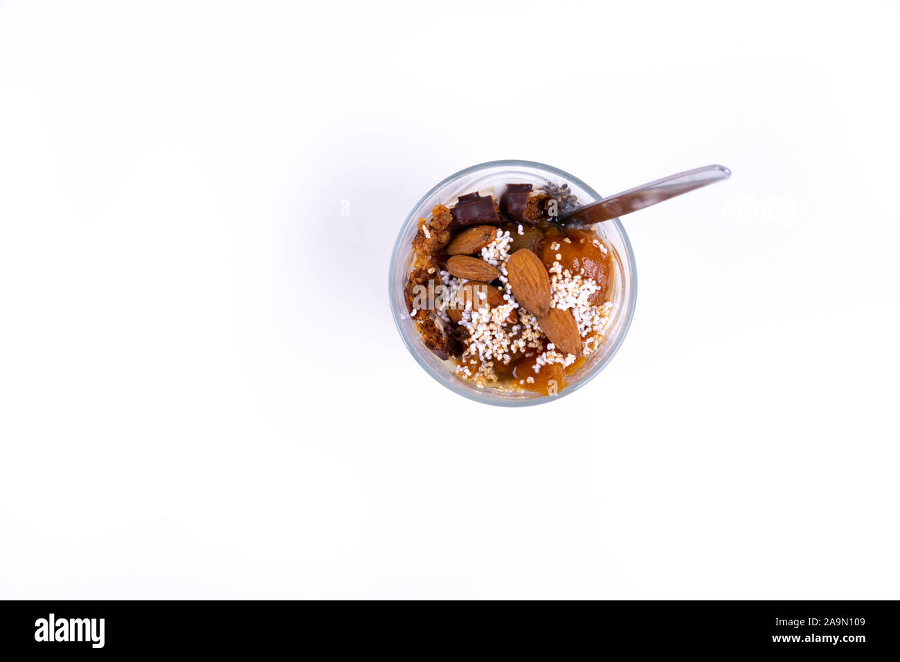 Eine vegane Wüste gemacht von Chia Pudding, Joghurt, Marmelade, Obst, Kekse und Mandeln auf weißem Hintergrund - Ansicht von oben Stockfoto