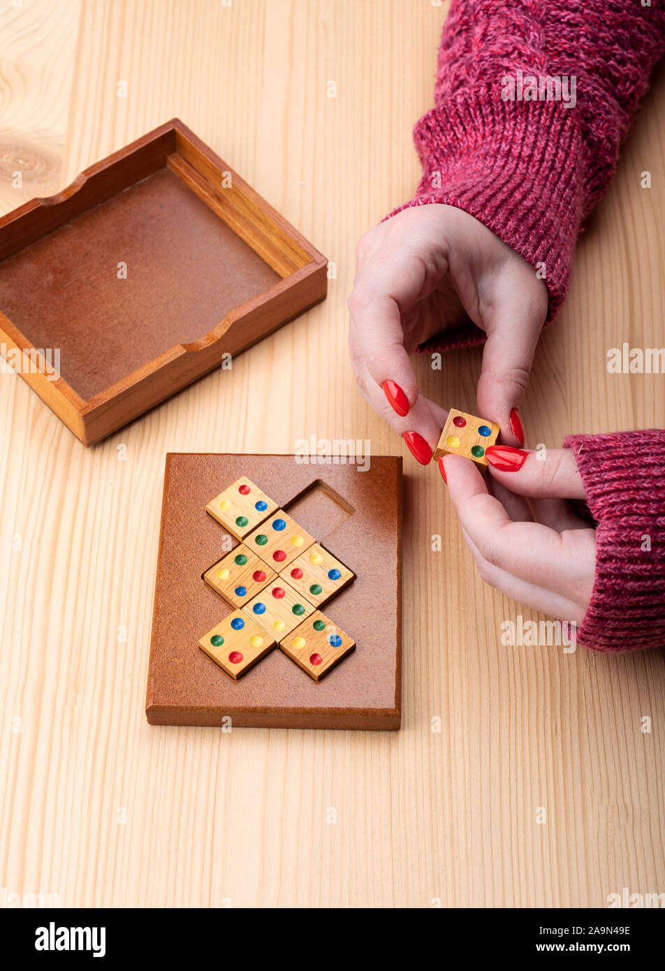 Mädchen versucht, ein Mosaik Puzzle zusammenzusetzen. Helle Maniküre auf Fingernägeln. Puzzles aus der Kategorie edge matching Puzzle. Kopieren Sie Platz. Puzzle Konzept Stockfoto