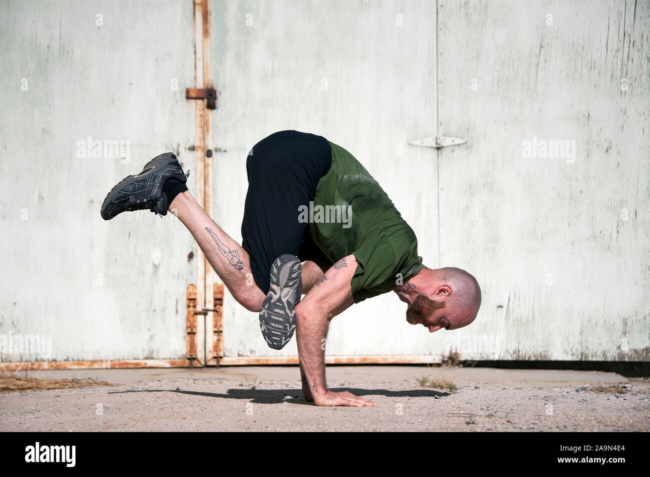 Im mittleren Alter Mann mit Bart Yoga durch die alte Farbe peeling Wand. Stockfoto