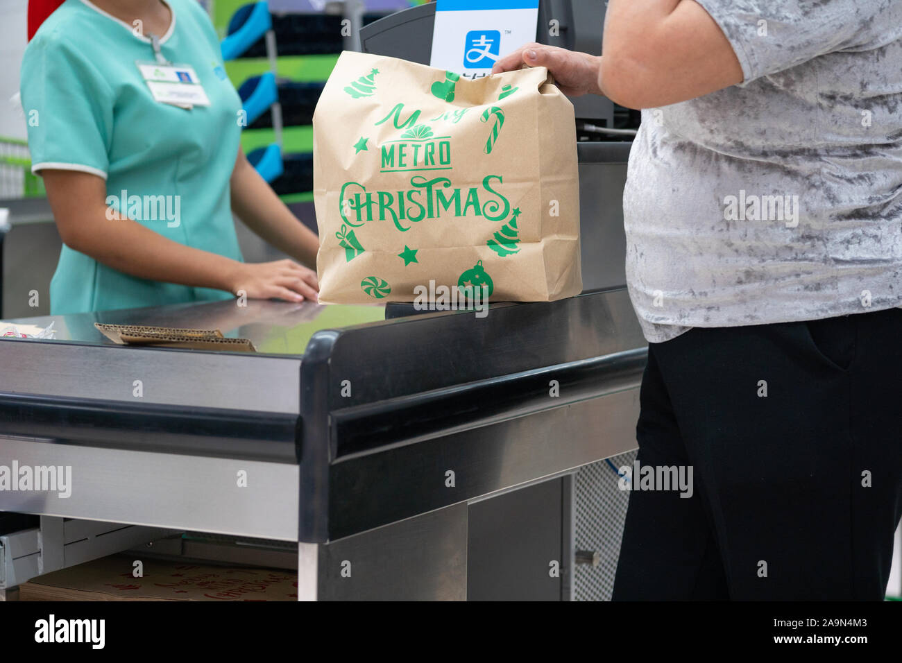 Eine Frau kaufen Lebensmittel, die in eine braune Papiertüte platziert werden. Mittwochs und Samstag sind keine Plastiktüte Tage in diesem besonderen speichern in Stockfoto