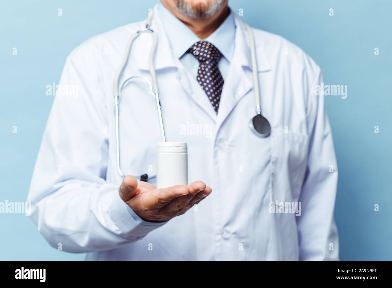 Arzt holding Flasche Pillen auf weißem Hintergrund. Das Konzept von Medizin, Pharmakologie, Gesundheitswesen Stockfoto