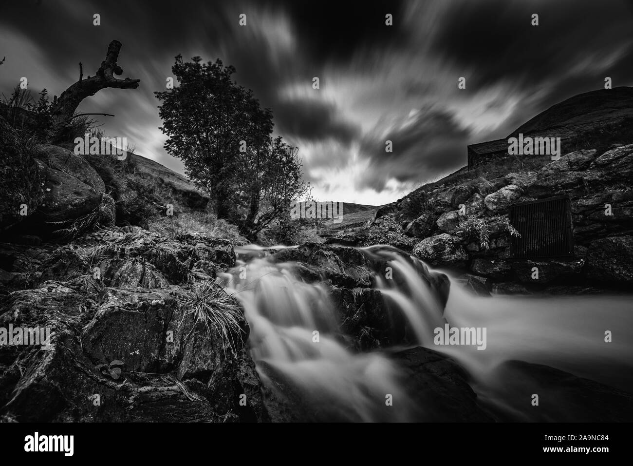 Lange Belichtung schießen Erfassung Kaskaden von Mountain Creek fluß an das malerische Tal im Lake District, ENGLAND - Monochrom bearbeiten Stockfoto