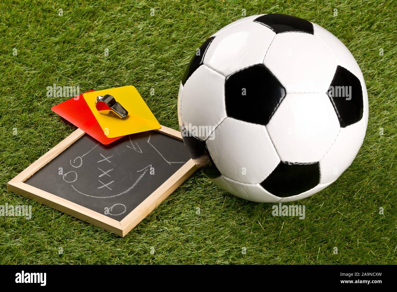 Fussball sport Ball und Schiedsrichter chrom Pfeife mit spiel strategie Zeichnung Blackboard und gelbe und rote Schiedsrichter Karten auf Gras Hintergrund - Selektive f Stockfoto