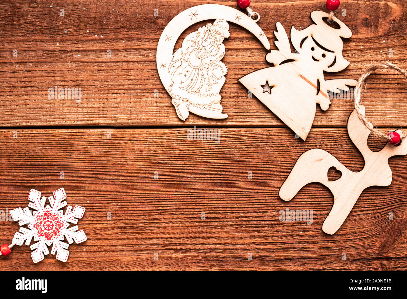 Weihnachten handgefertigte ökologischen Handwerk Holz Dekorative Spielzeug für Xmas Tree: Reh, Engel, Schneeflocke und Santa Claus auf dem Mond an einem Seil mit Perlen auf Braun Stockfoto