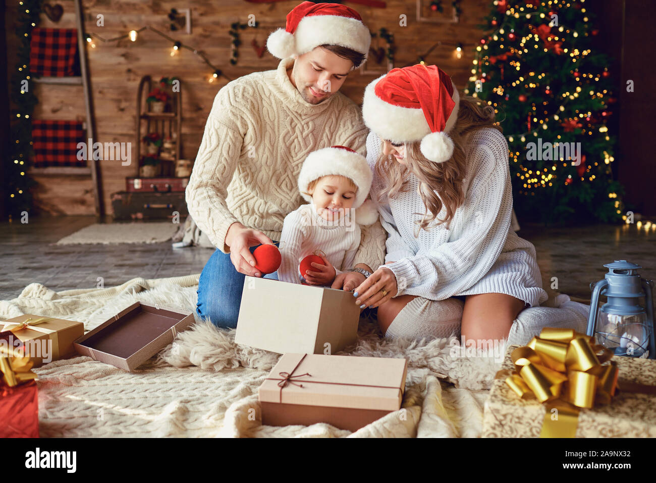 Die Familie bietet Geschenke an das Kind im Zimmer in Weihnachten Stockfoto