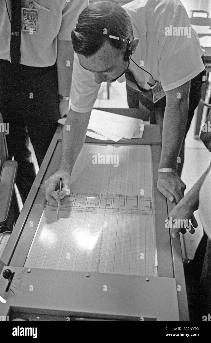 S 69-39588 (20 Juli 1969) --- Dr. Garry Latham, mit der Lamont Geological Observatory, Studien seismometer Pausen im Mission Control Center? s ASEP-Kontrollraum. Die elektronischen Daten kommen von der Passive seismische Experimente Pakets, das Apollo 11 Astronauten nur auf der Oberfläche des Mondes bereitgestellt hatte. Stockfoto