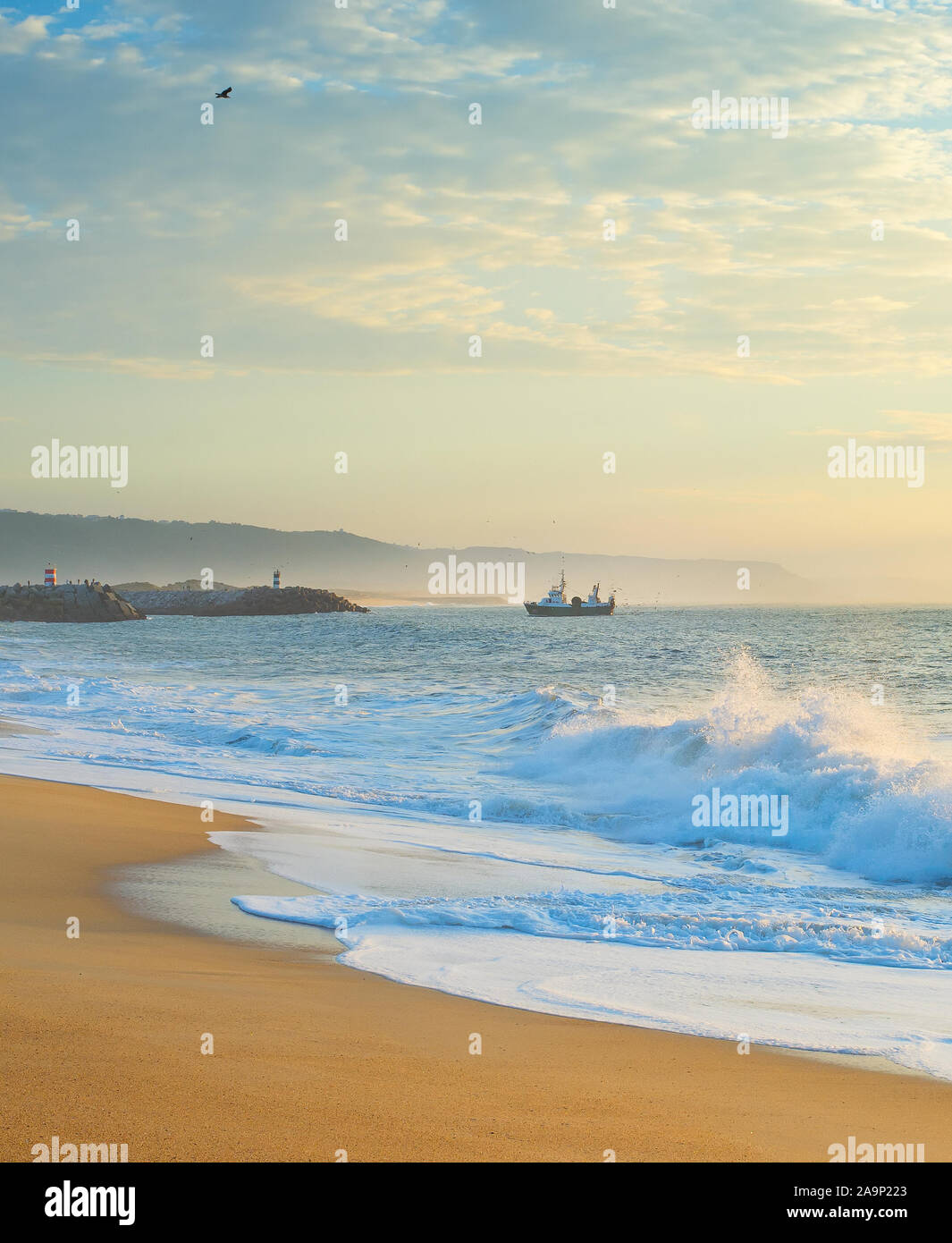 Landschaft mit dem Ocean Beach, Angeln Schiff bei Sonnenuntergang. Nazare, Portugal Stockfoto