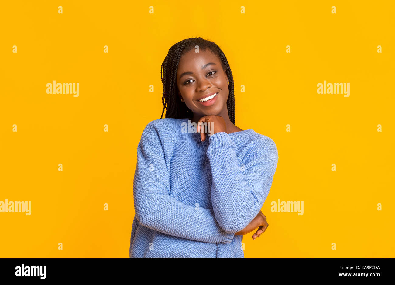 Interessierte afro Dame lächelnd auf gelbem Hintergrund Stockfoto