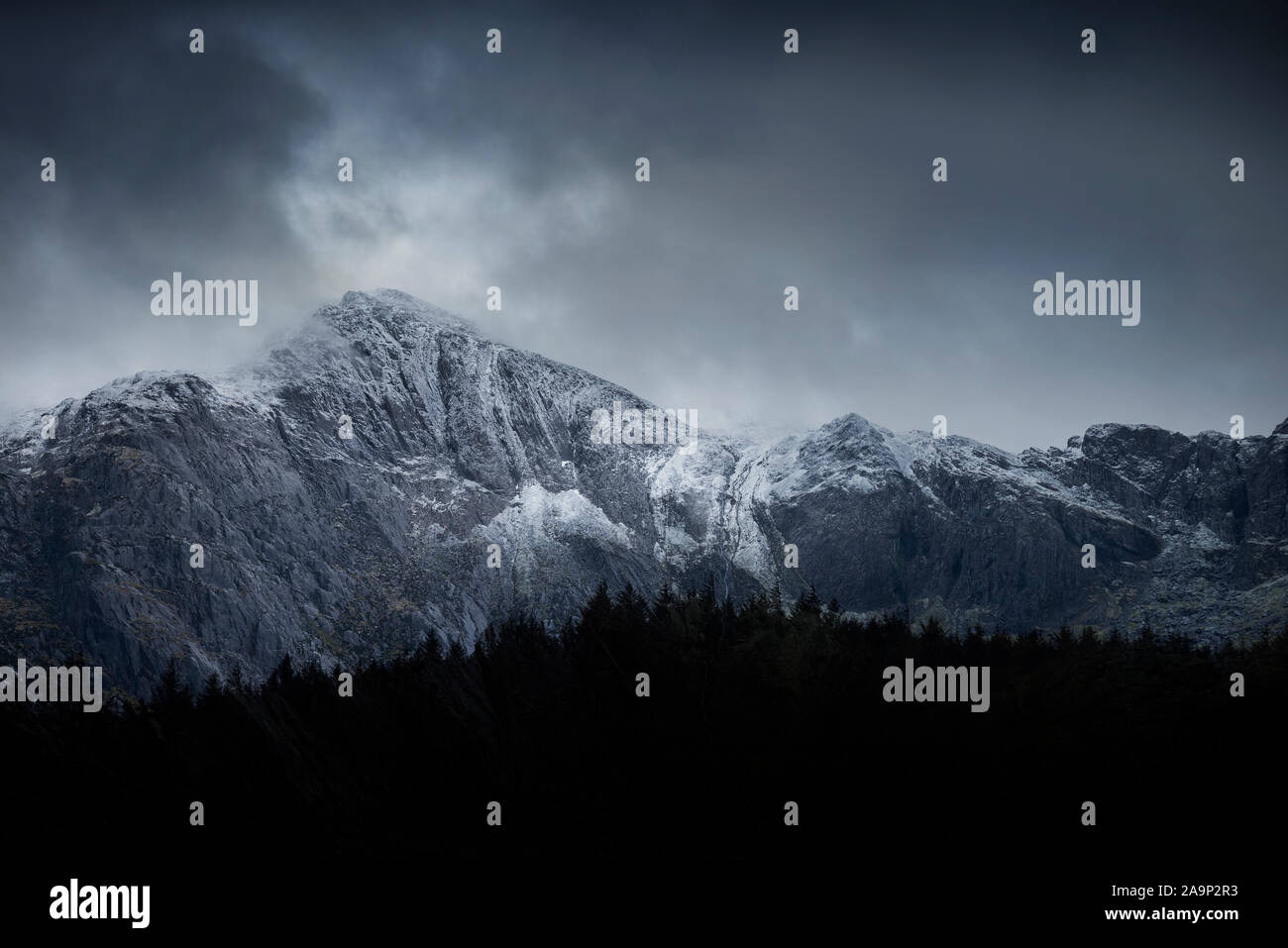 Atemberaubende dramatische Landschaft Bild von schneebedeckten Glyders Bergkette in Snowdonia im Winter mit bedrohlichen Wolken am Berg Erbse hängen Stockfoto