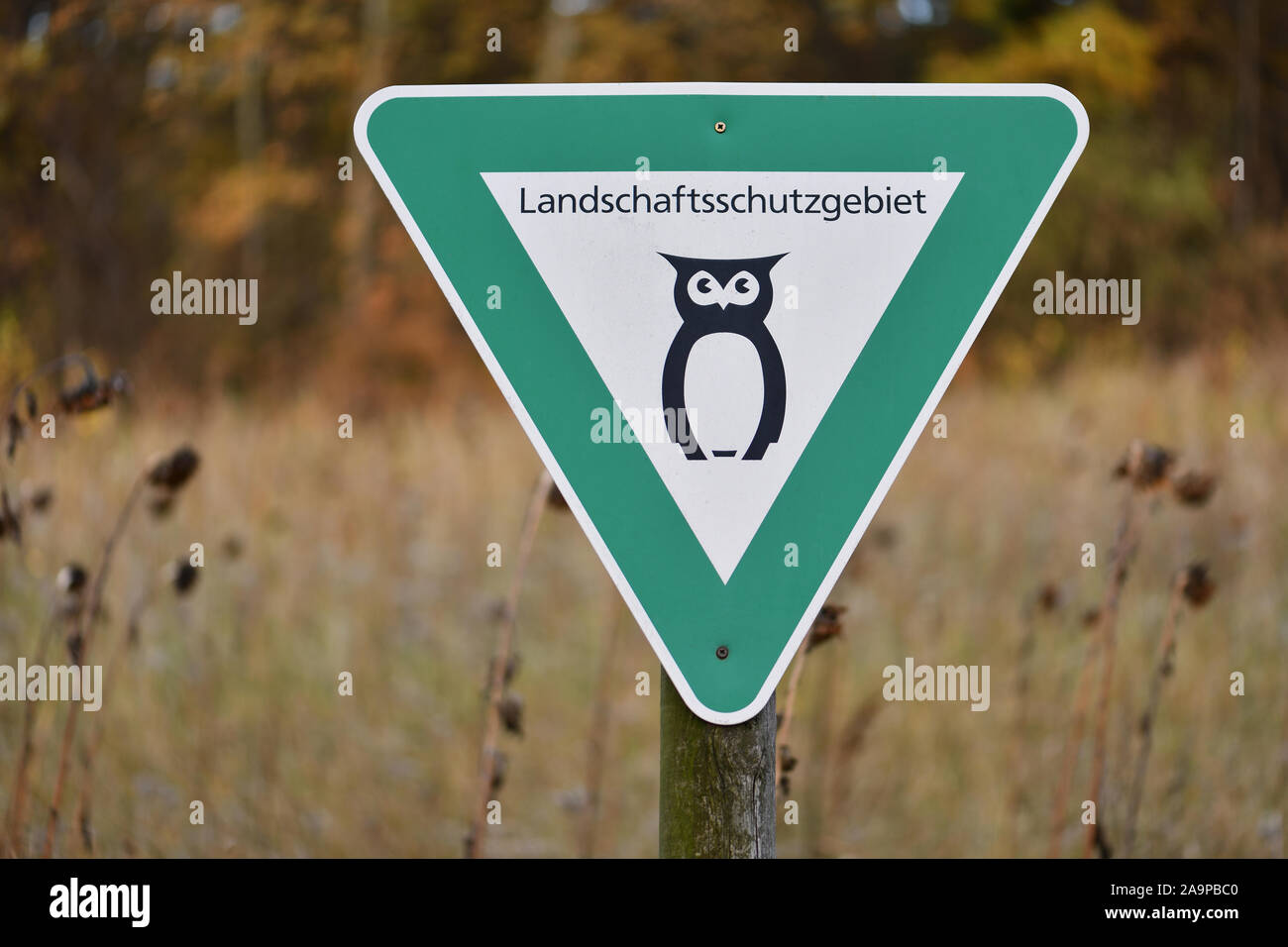 Naturschutzgebiet in Niedersachsen, Deutschland. Grünes Schild mit schwarzem Eule zeigt eine Landschaft finden. Symbol für deutsche Landschaftsschutzgebiet. Stockfoto