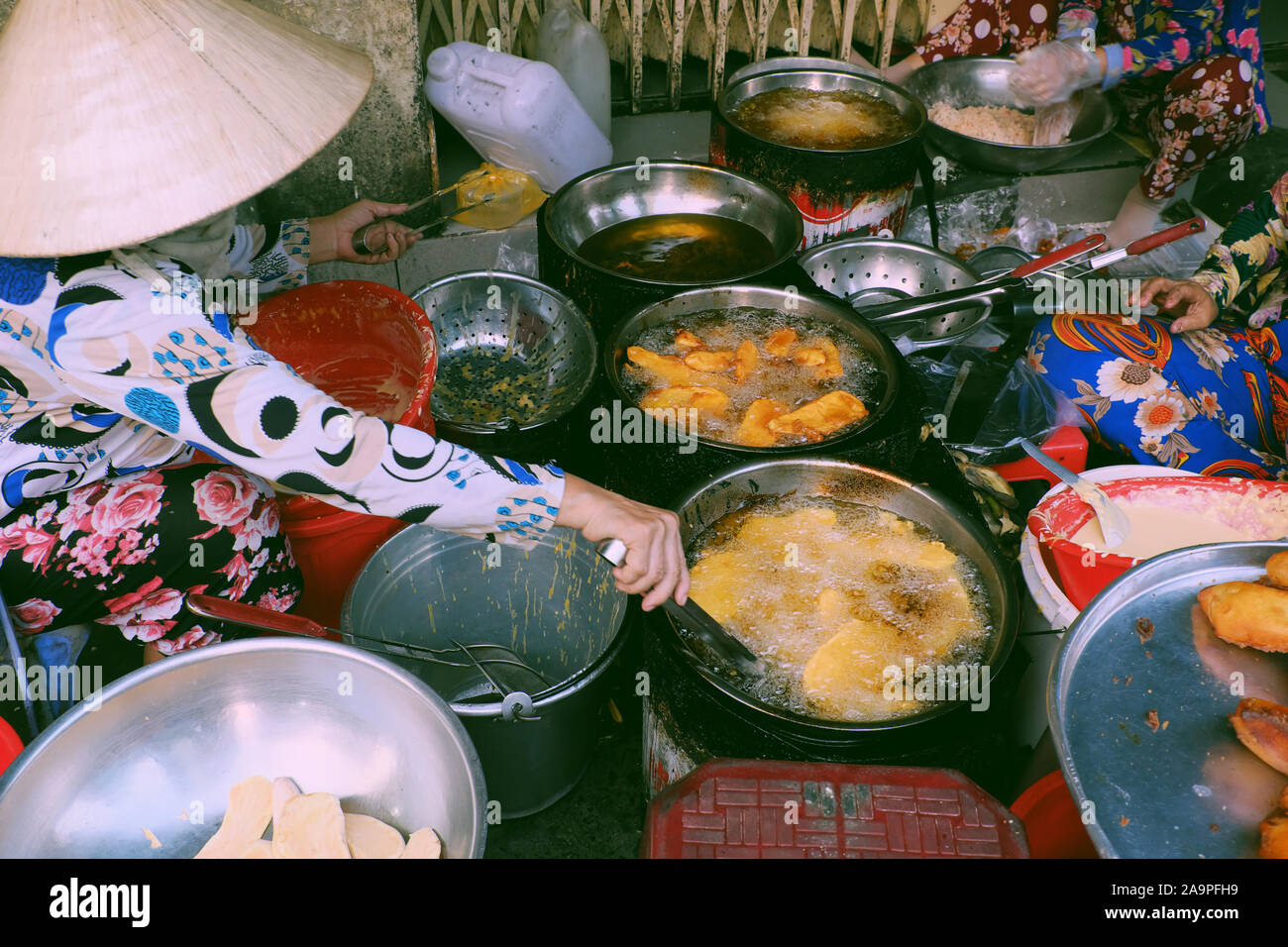 Vietnamesische Outdoor-Food-Straße in Ho Chi Minh Stadt am Abend, Tablett mit knusprigen Snacks Kuchen aus Pulver in Speiseöl so lecker frittiert Stockfoto