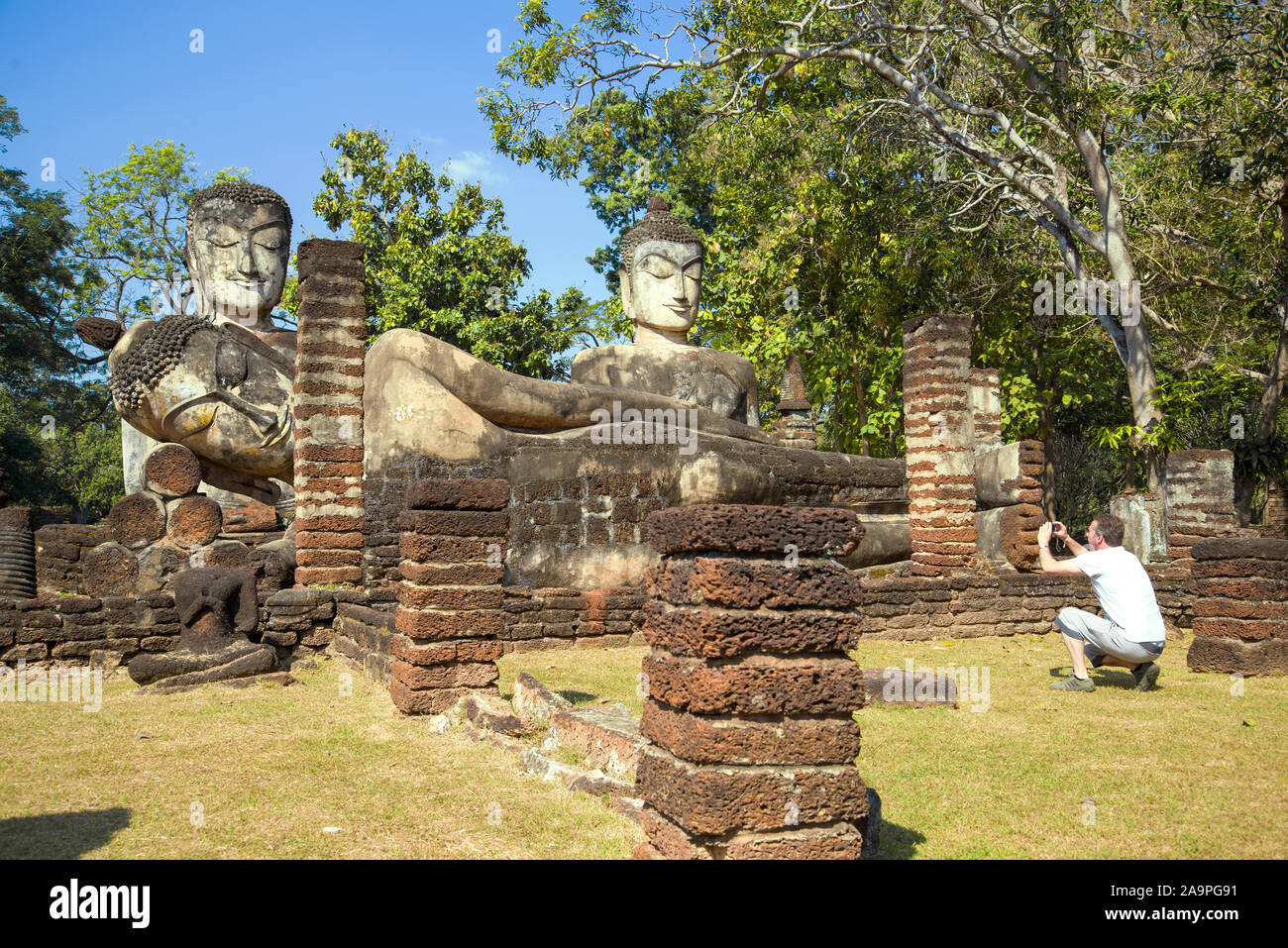 KAMPHENG PHET, THAILAND - 30. Dezember 2016: Europäische Touristen Fotos Buddha Skulpturen auf den Ruinen des buddhistischen Tempel Wat Phra Kaeo Stockfoto