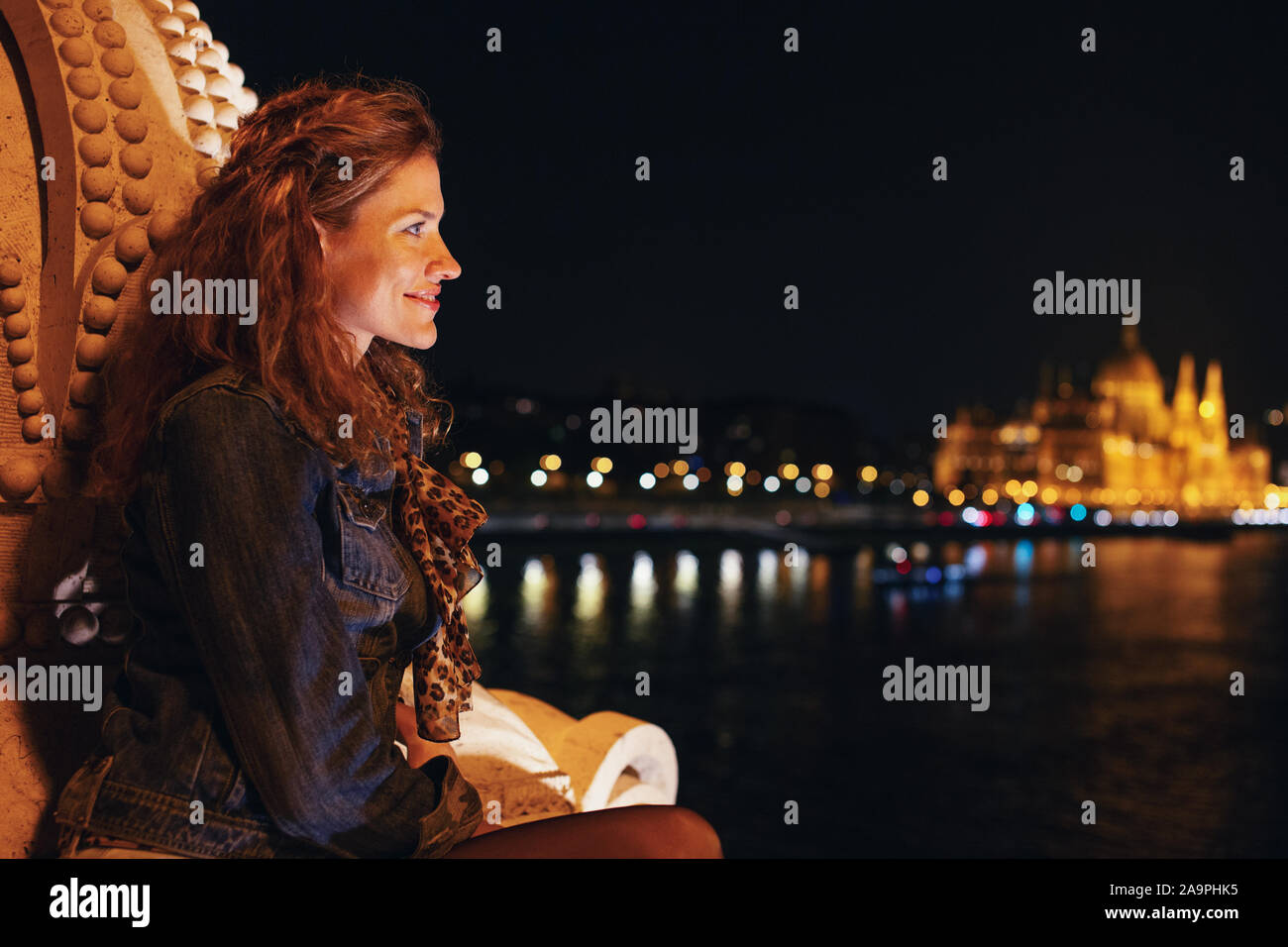 Glückliche junge rothaarige Frau, die mich Nacht Panorama in Budapest, Ungarn Stockfoto