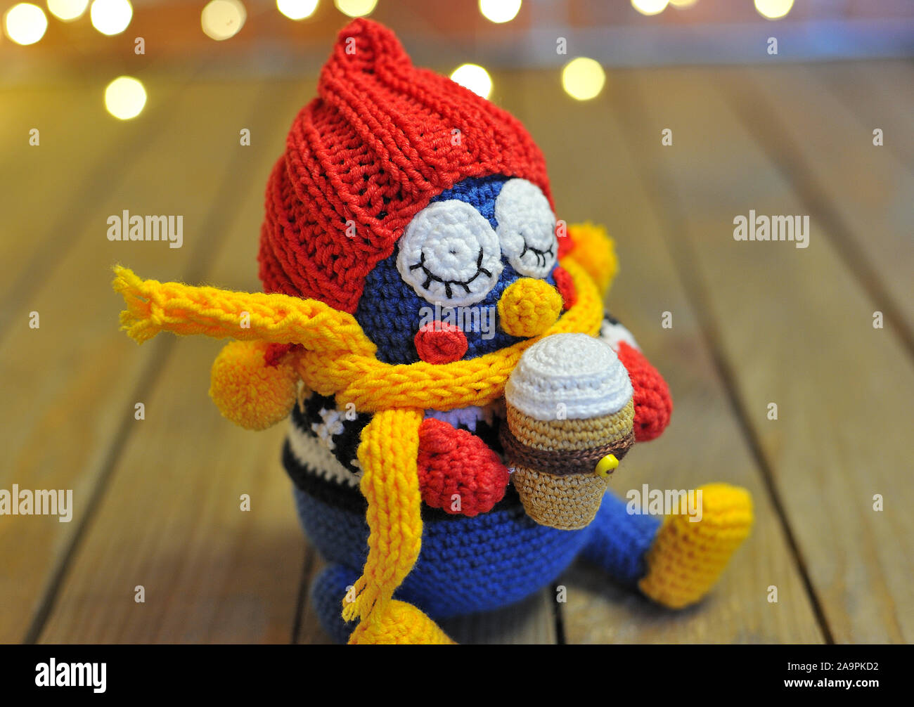 Gestrickte owl Eule mit Eis. Spielzeug vor dem Hintergrund von Garland ist ein Neues Jahr Stockfoto