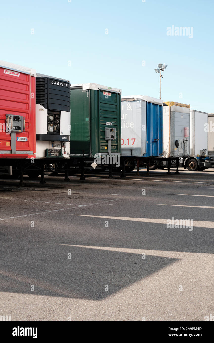 Eine Reihe von geparkten Lkw Anhänger mit Schatten und blauer Himmel - Nutzfahrzeuge - Lkw - Lastkraftwagen - LKW-Park - Geparkte große Nutzfahrzeuge - Ware depot Stockfoto