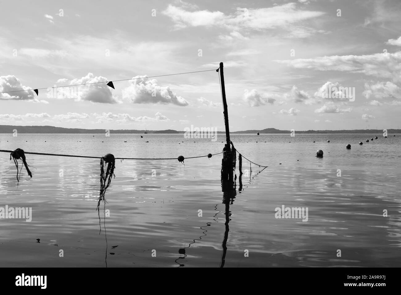 Bolsena see Anzeigen mit Bojen und Fischernetze gegen einen blauen Himmel mit einigen Wolken. Hügeln im Hintergrund. Bolsena See, Italien. Stockfoto
