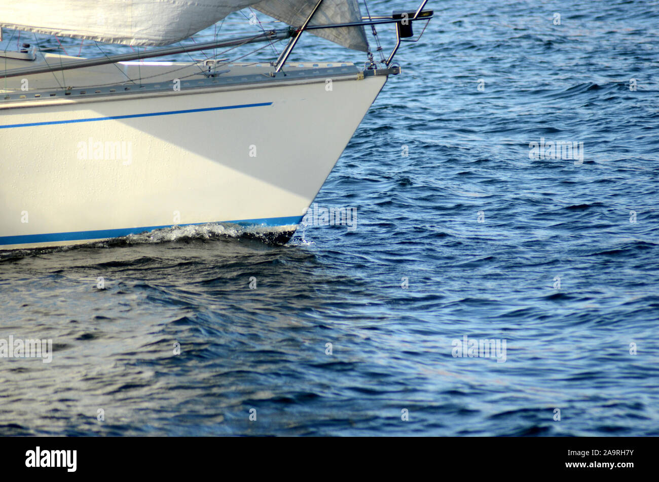 Der Bug eines GFK Yacht Pflüge über ein ruhiges Meer Oberfläche. Stockfoto