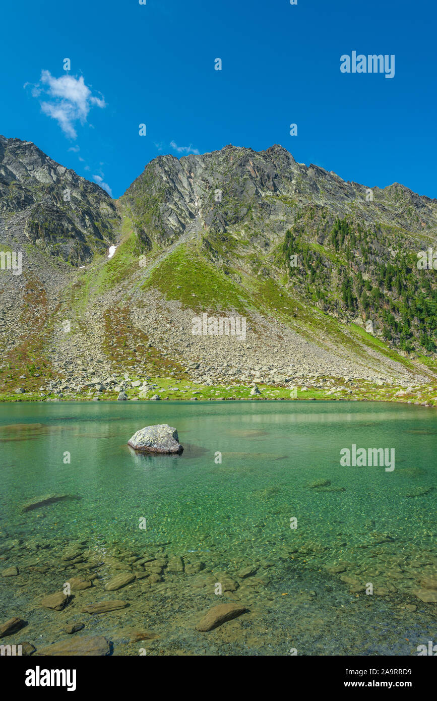 Wundervolle Emerald Lake an Klausee, schroffe Berge mit Erdrutsch Rutsche. Große einsame Felsbrocken, die aus dem See. Stockfoto