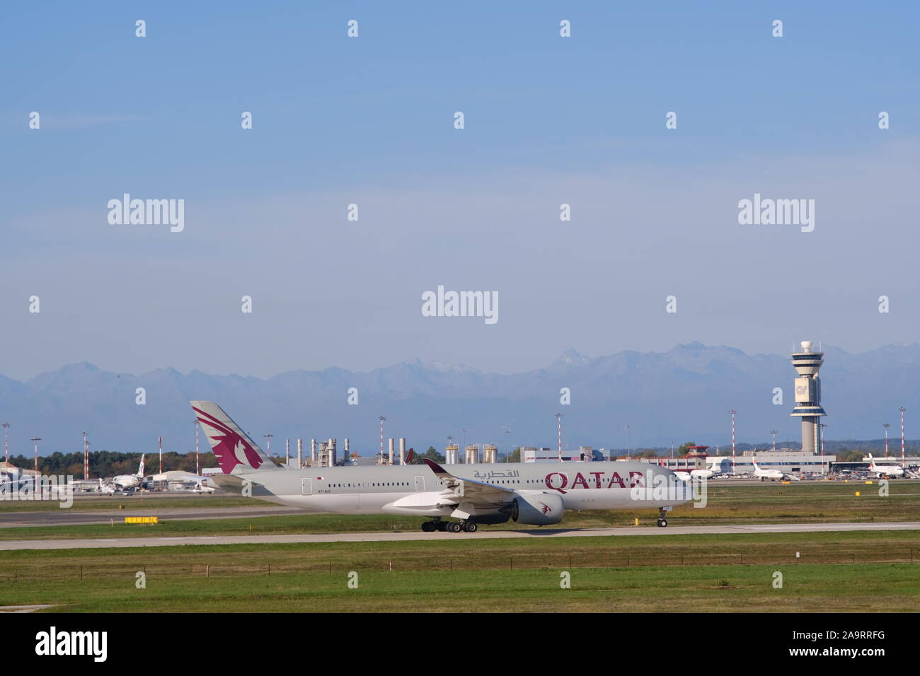 Mailand, Malpensa, Italien, ca. 10/2019. Quatar Airbus A 350-941 Flugzeug rollen auf den Malpensa Flughafen Landebahn. Im Hintergrund der Control Tower. Stockfoto