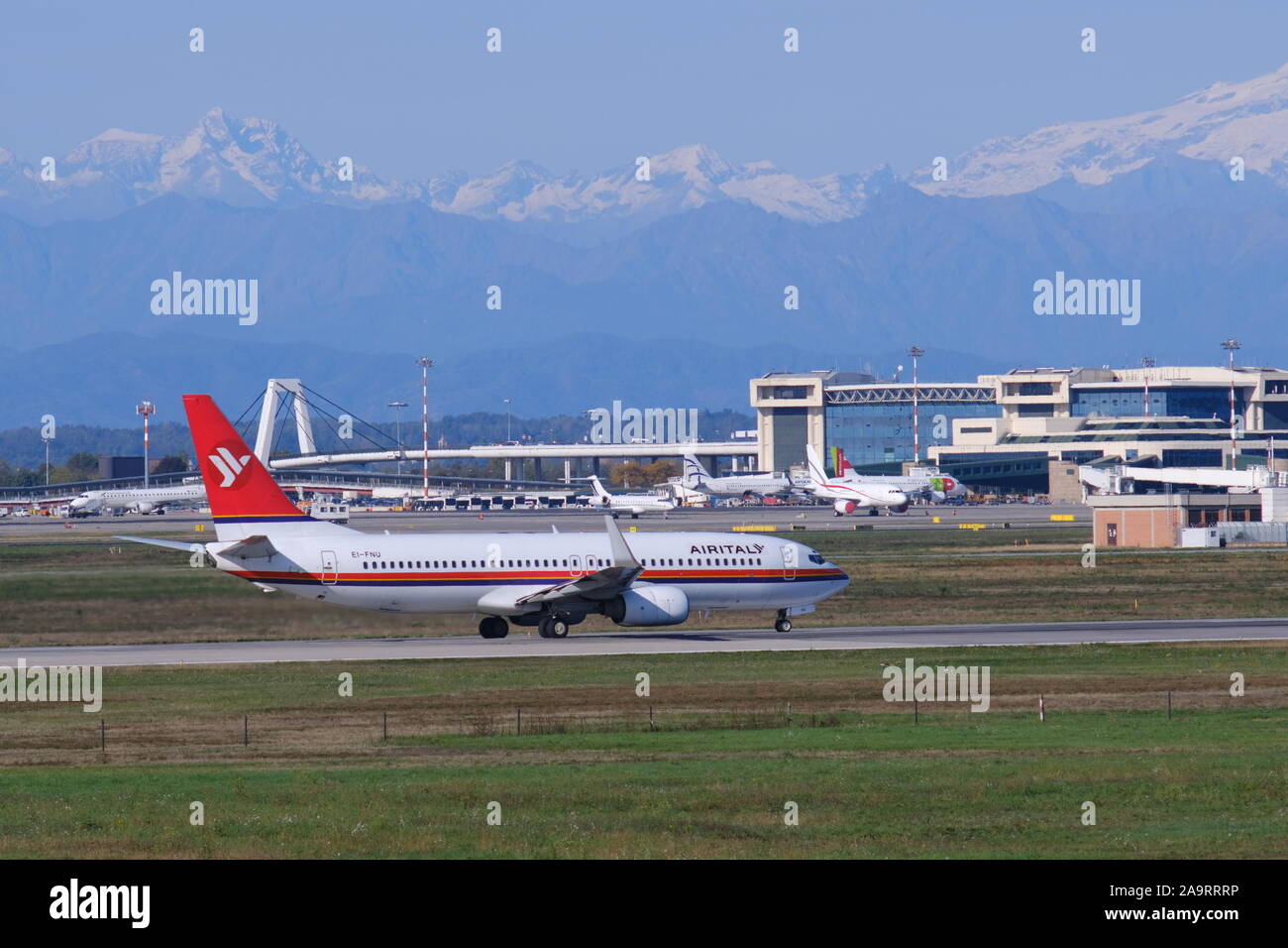 Mailand, Malpensa, Italien, ca. 10/2019. Air Italy Boeing 737-800 Flugzeug auf dem Flughafen Malpensa Landebahn. Im Hintergrund das Gebäude des Terminals Stockfoto