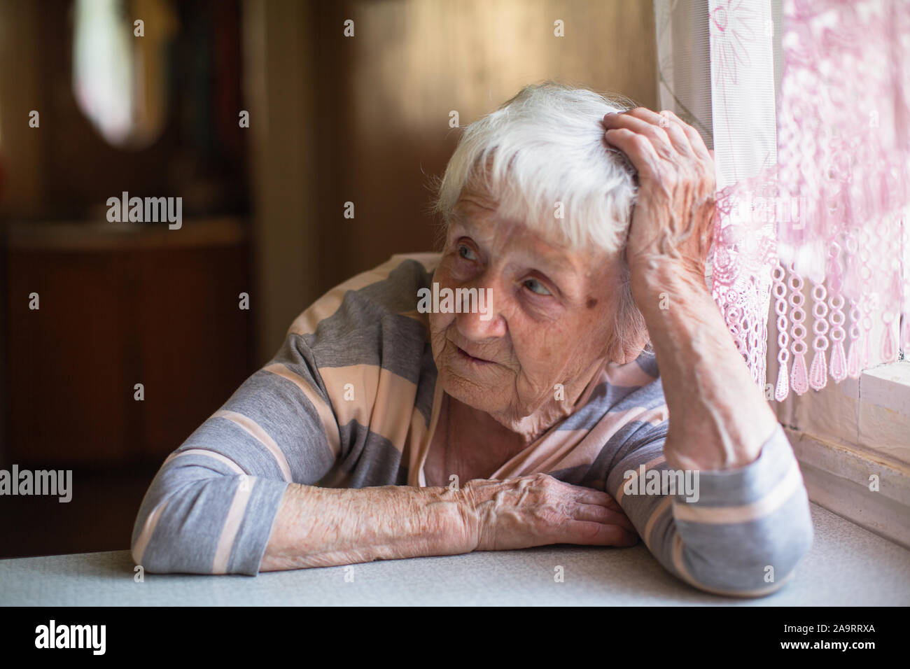 Porträt eines Rentners alte Frau am Tisch im Hause sitzen. Stockfoto
