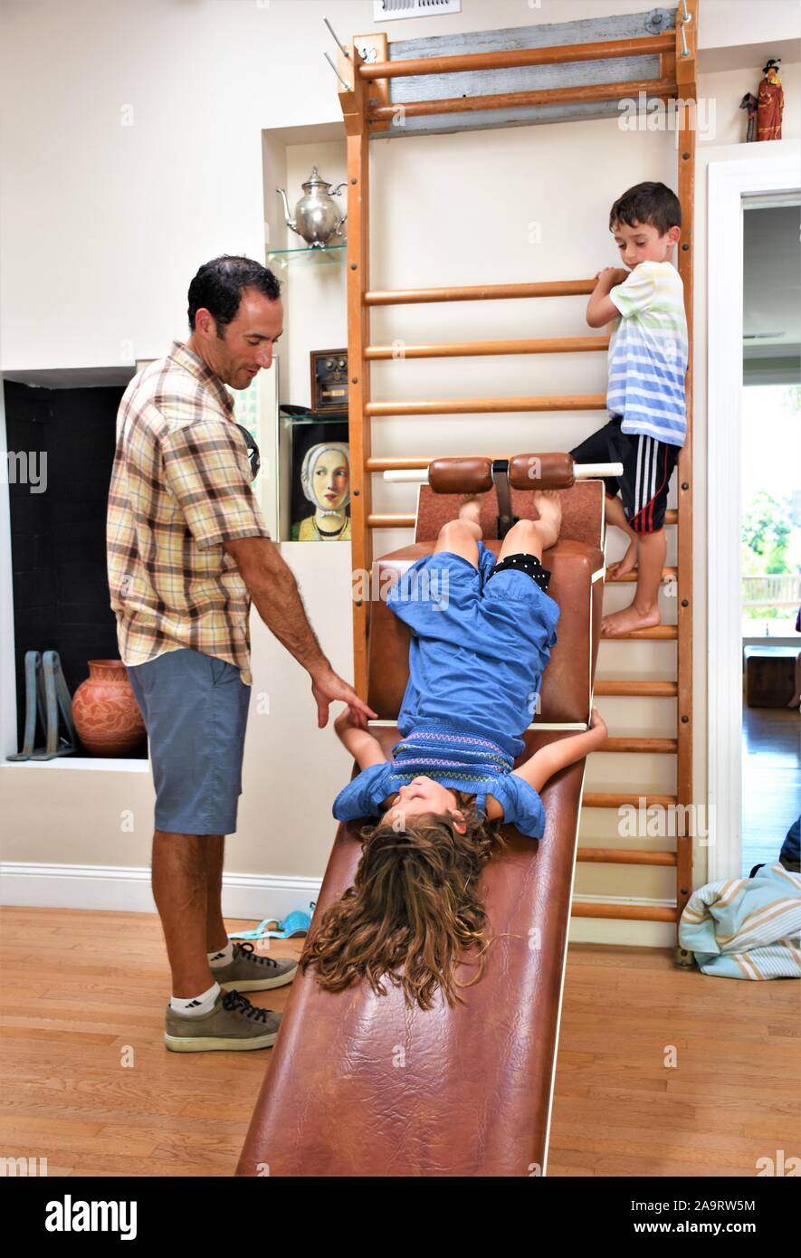 40 Jahre alten Vater mit Sohn und Tochter spielen und lernen zu Hause Trainingsgeräte für Spaß und pädagogische Fähigkeiten Stockfoto