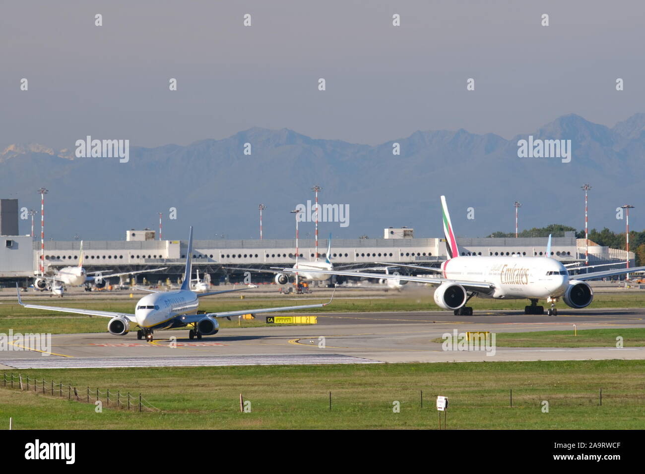 Mailand, Malpensa, Lombardei, Italien. Über 10/2019. Emirates Boeing 777-31 H Flugzeug auf dem Flughafen Malpensa Landebahn. Im Hintergrund das Terminal 1. Stockfoto