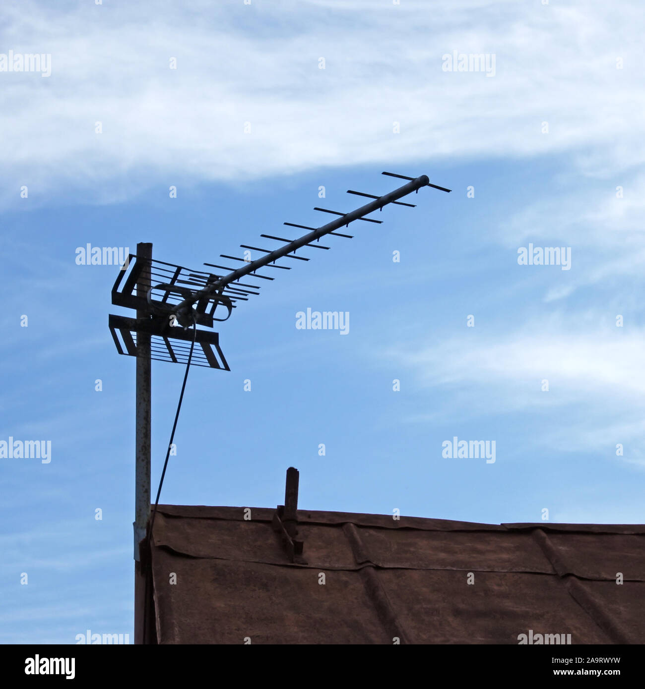 Fernsehen Antenne über alte Metall Dach auf dem Himmel Hintergrund Stockfoto