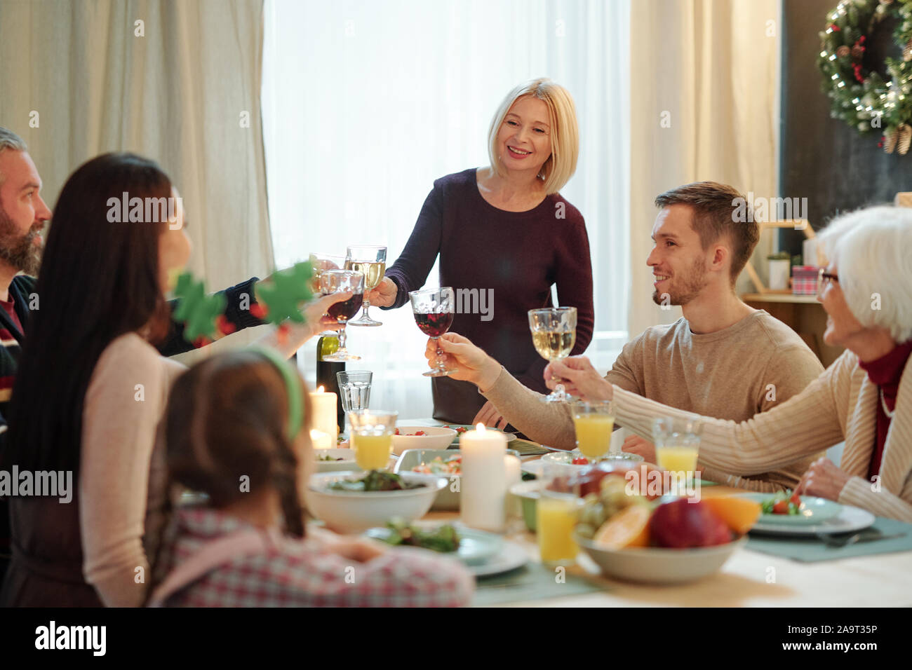 Blonde reife Frau und ihrer Familie Mitglieder klirren mit Gläsern Wein Stockfoto