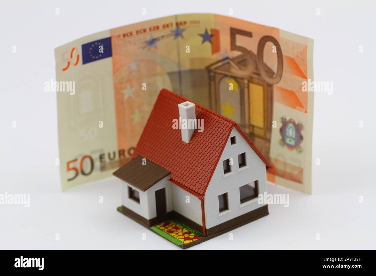 Miniatur Kunststoff Haus mit Euro-banknoten im Hintergrund Stockfoto