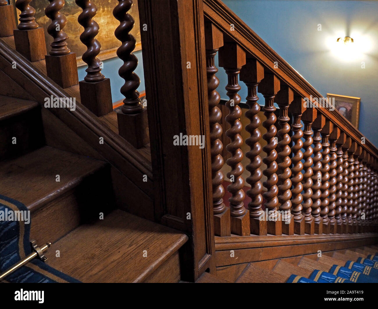 Poliertes Holz Treppe mit eingeschaltet twisted Balustraden, brass Stair rods und eleganten Geländer in einem englischen Landhaus. Stockfoto