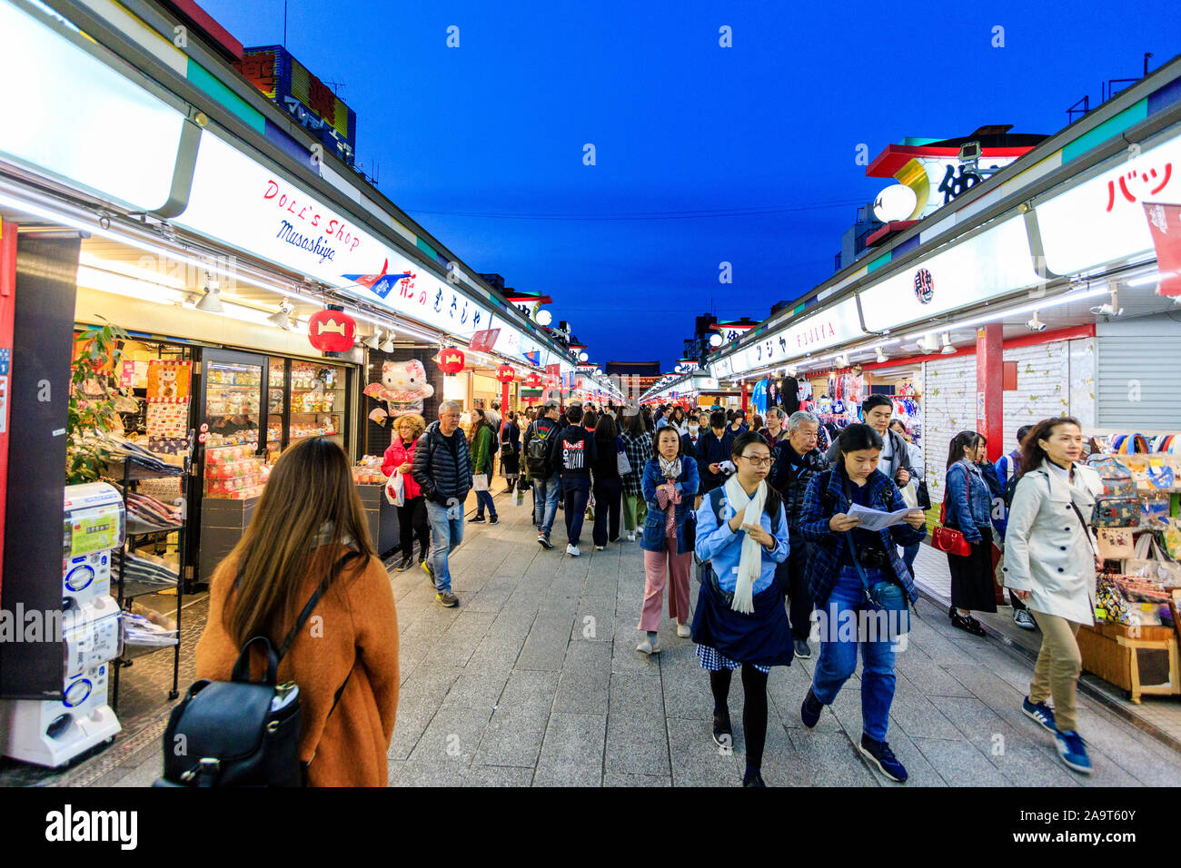 Tokio, Schrein und Sensoji-Tempel in Asakusa. Die Einkaufsstraße Nakamise mit Menschen vorbei gehen Essen und Souvenirläden mit Temple Gate hinter sich. Nacht. Stockfoto