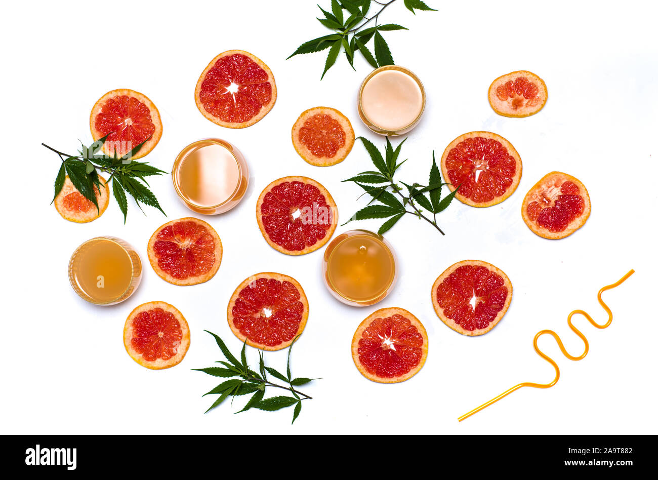 Grapefruitsaft mit Marihuana mit fruchtschnitten auf Weiß flach Stockfoto