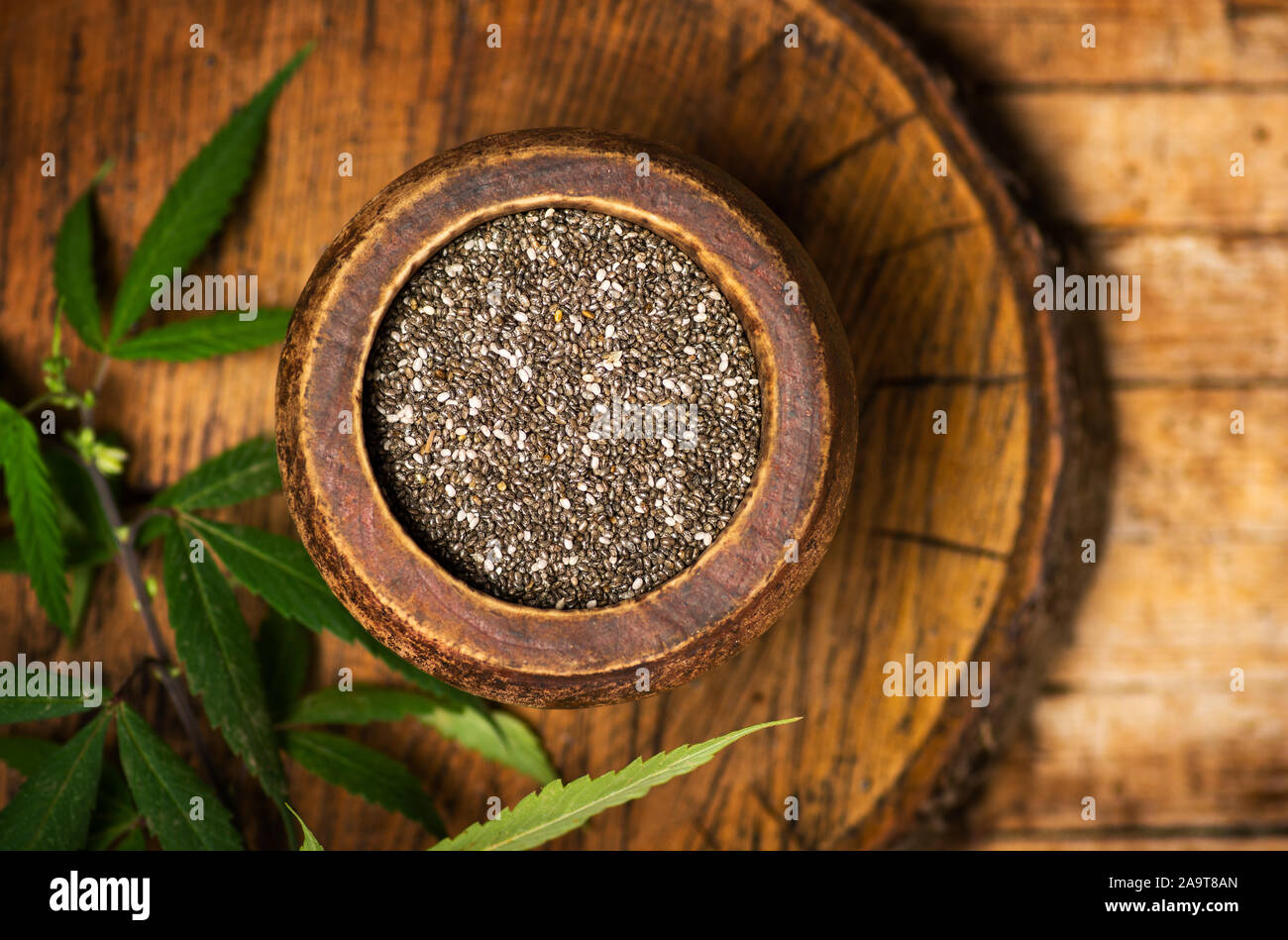 Chia Samen und Marihuana Blätter in einer Schüssel auf einem hölzernen Hintergrund Stockfoto