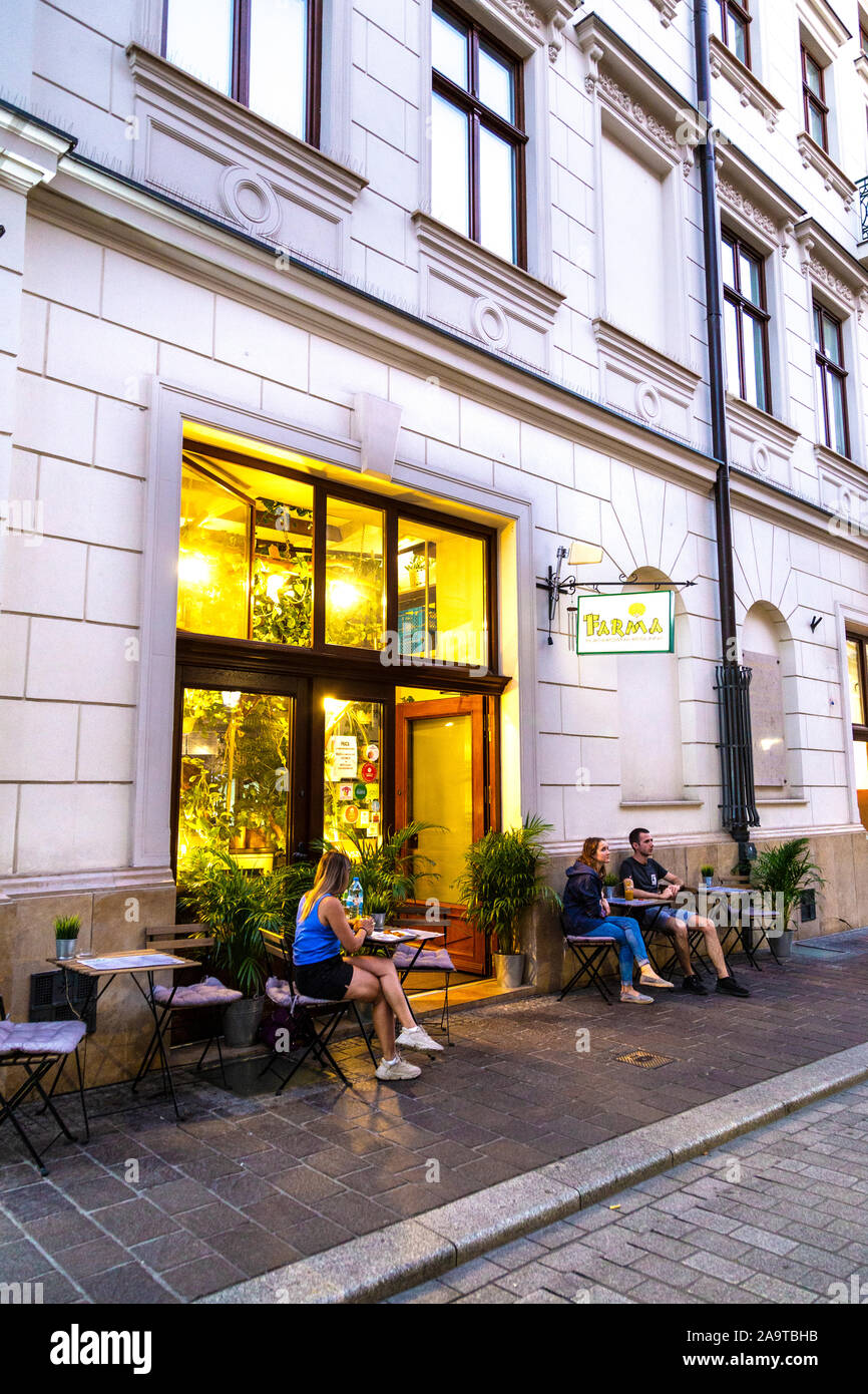 Die Leute draußen sitzen Vegane Burger Restaurant Farma in Krakau, Polen Stockfoto