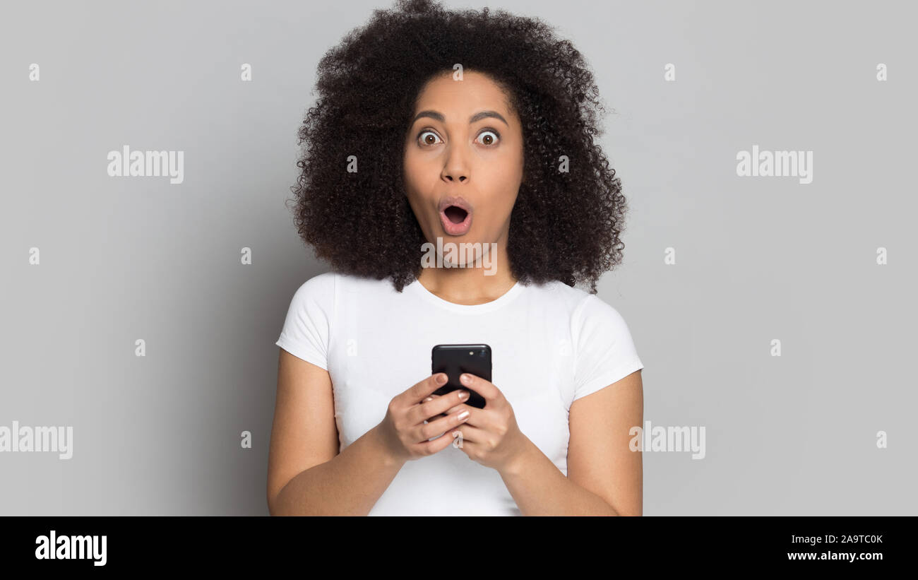 Kopf geschossen Porträt überrascht Afrikanische amerikanische Mädchen mit Telefon Stockfoto