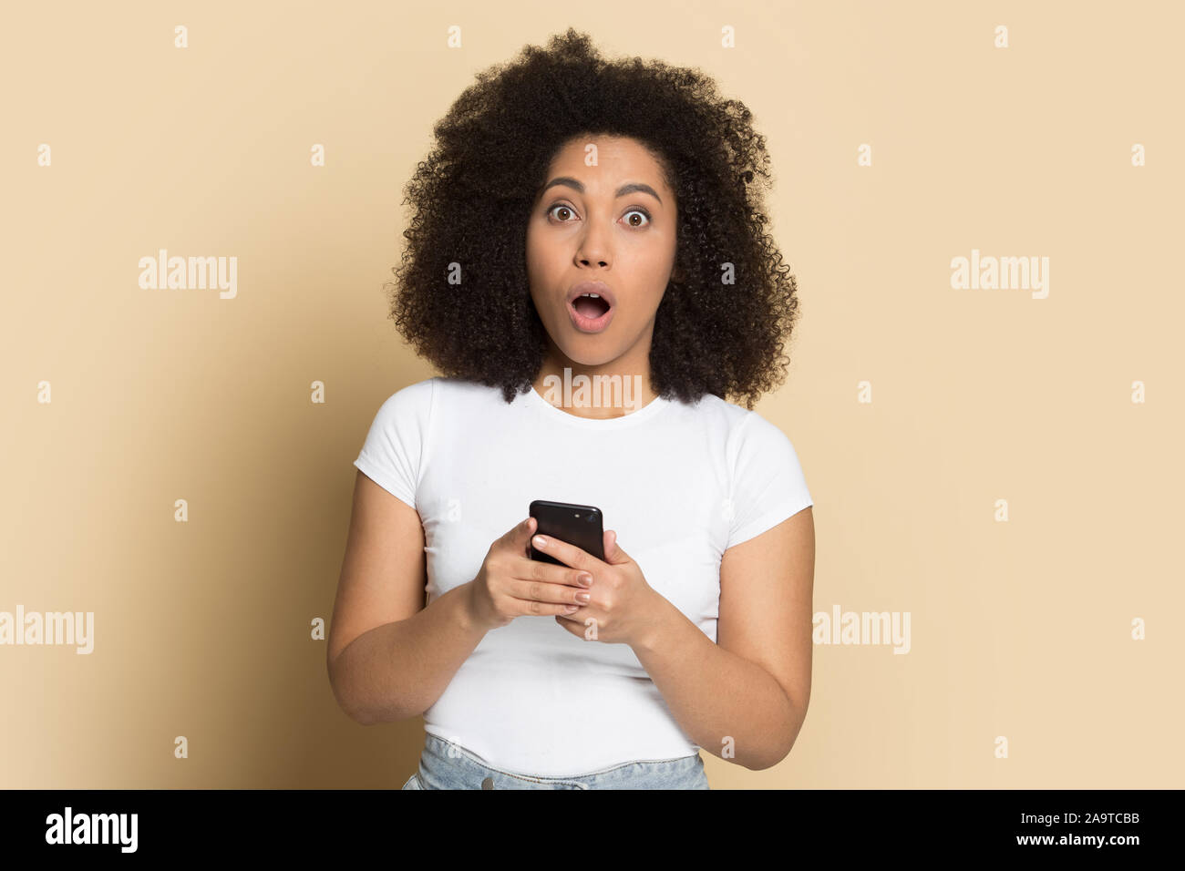 Kopf geschossen Porträt überrascht Afrikanische amerikanische Mädchen mit Telefon Stockfoto
