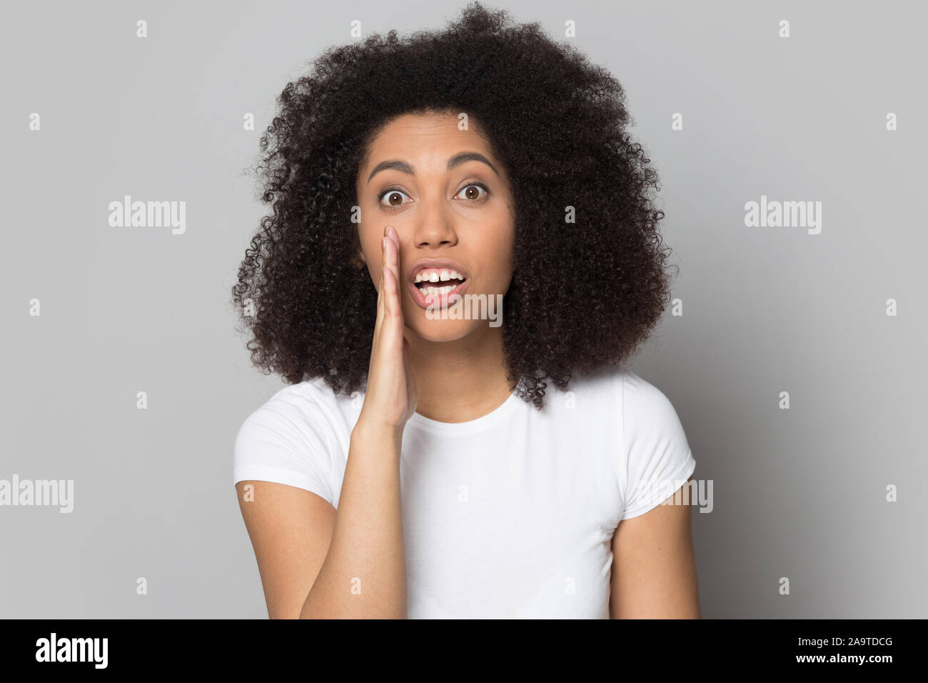 Kopf geschossen Portrait aufgeregt African American Girl sharing Geheimnisse Stockfoto
