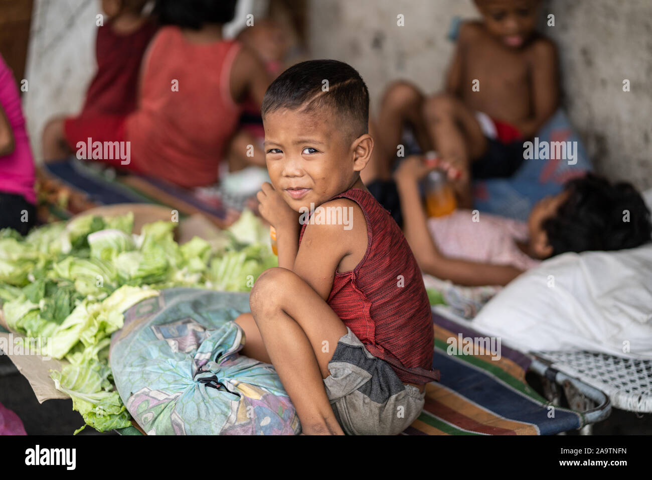 Eine junge Filipino Junge schaut in Richtung der Kamera in einer armen coommunity, Cebu City, Philippinen. Stockfoto