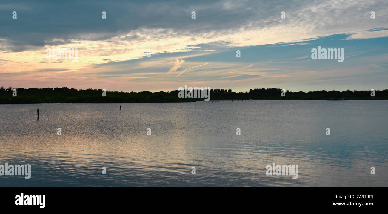 Blick über den großen See (in der Norfolk Broads, UK) bei Sonnenuntergang. Blaues Wasser und Himmel drehen orange, rot und rosa inmitten der Wolken, in der ge wider Stockfoto