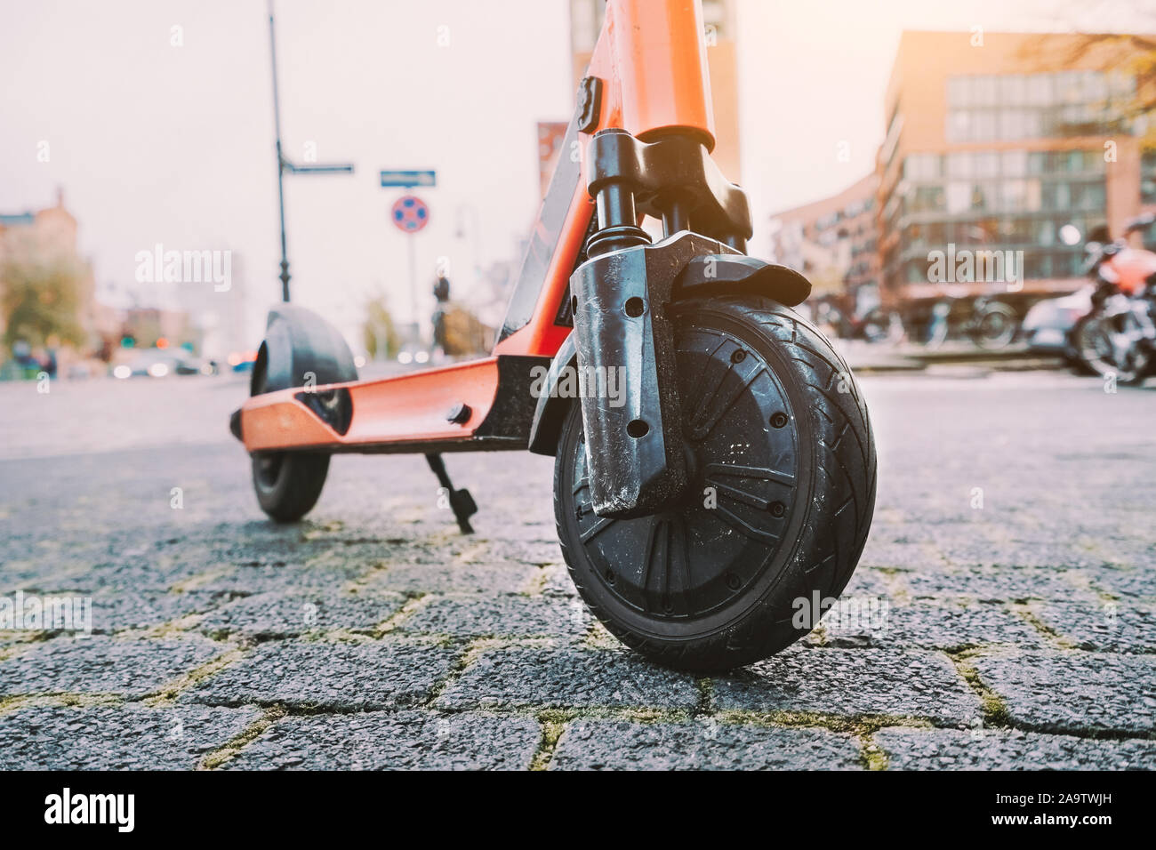 Lila e-Scooter Vorderrad reifen Perspektive geparkt im Freien am Gehsteig der Stadt Szene. Hamburg, Deutschland, Europa. Stockfoto