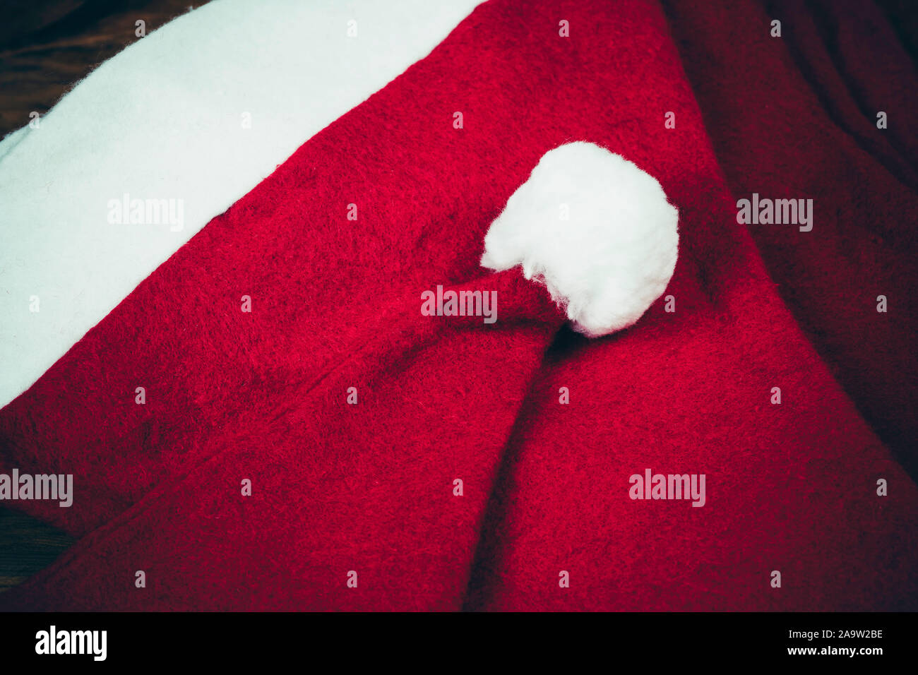 Weihnachten Hüte auf einen hölzernen Tisch. 2 rote Weihnachtsmütze auf einem vintage Holz Oberfläche. Weihnachten Konzept. Santa Claus Kappen. Stockfoto