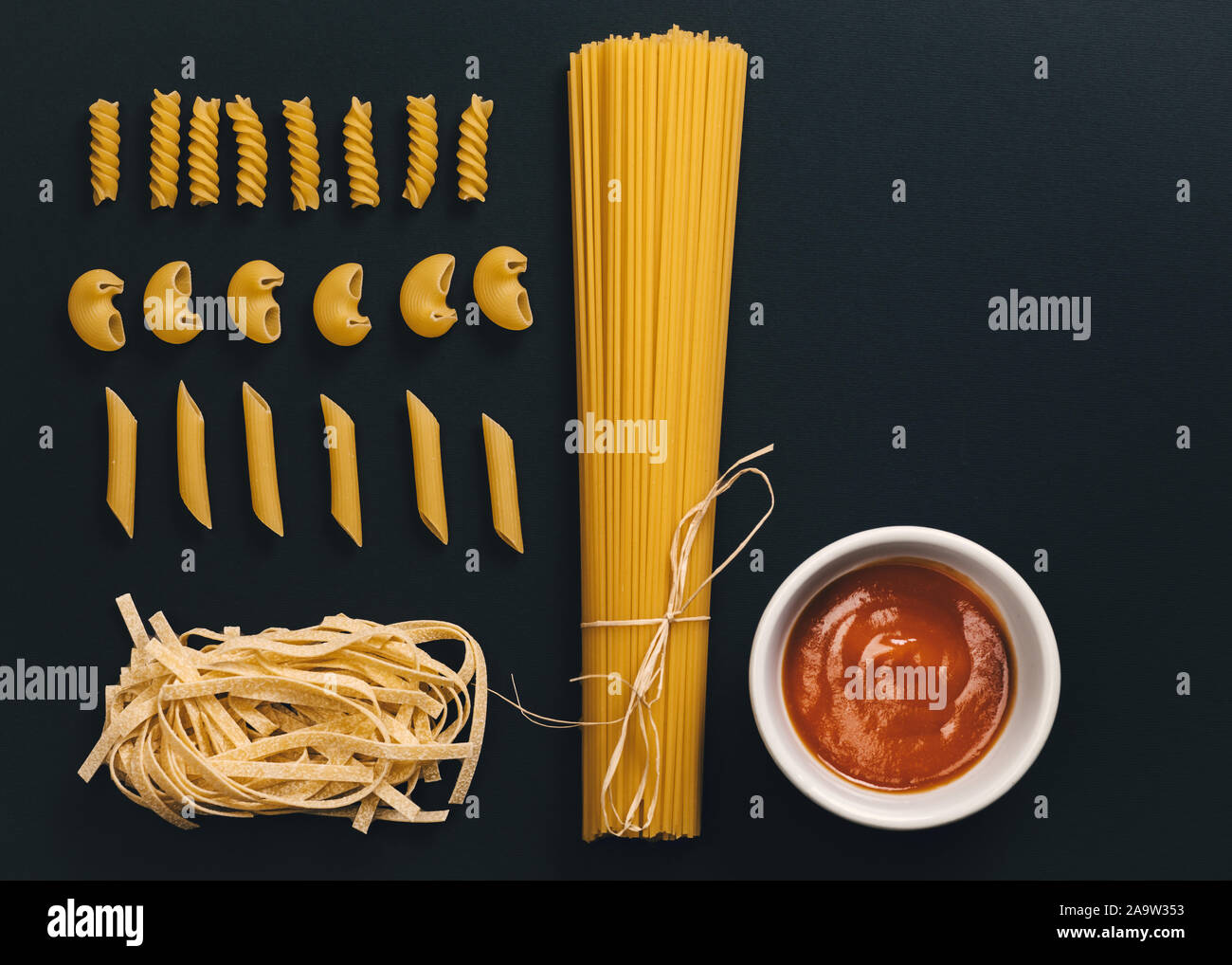Verschiedene Formen von Nudeln und Spaghetti auf schwarzem Hintergrund. Stockfoto