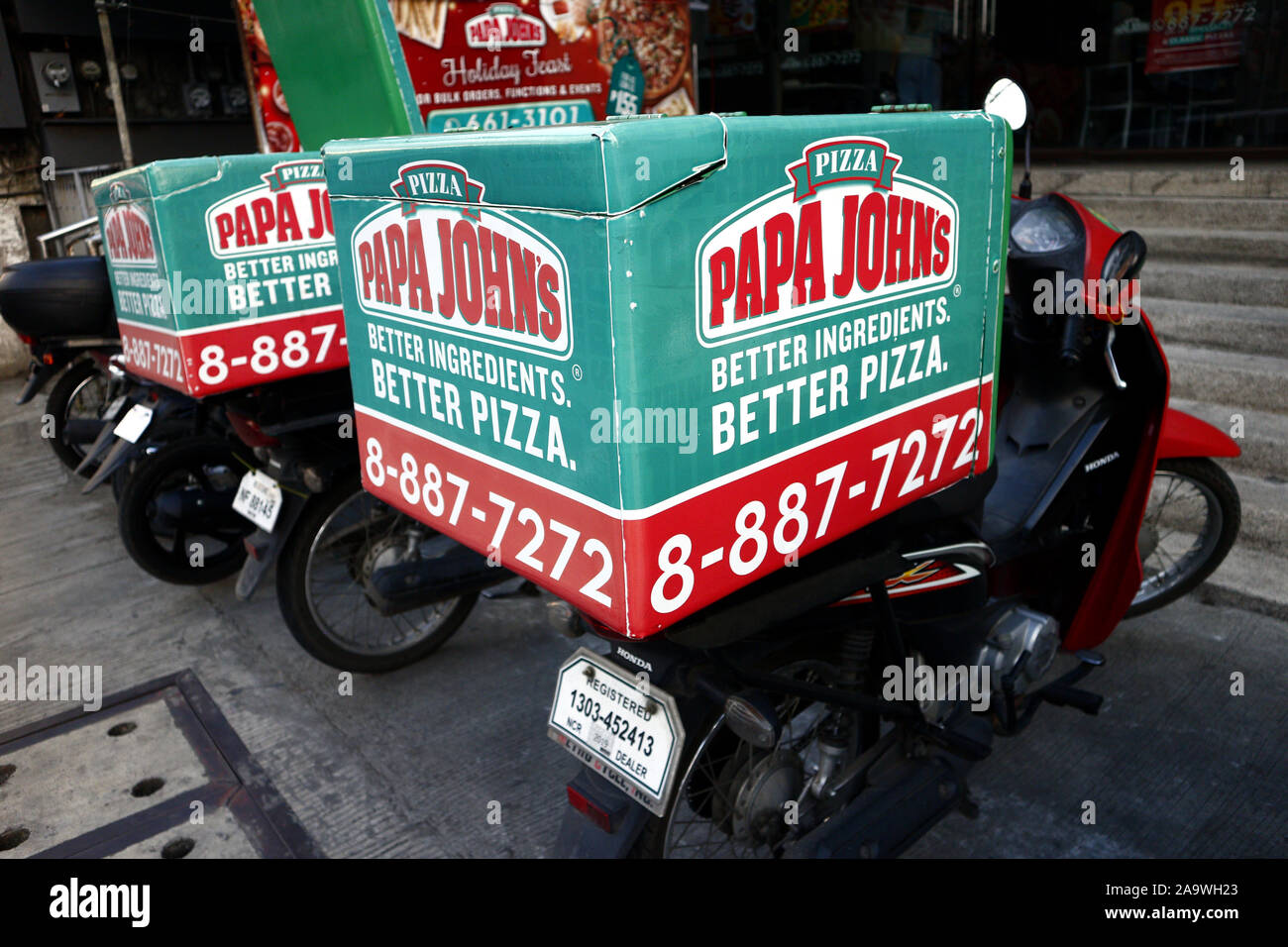 ANTIPOLO CITY, Philippinen - 16. NOVEMBER 2019: Geparkte Motorräder Lieferung eines beliebten Pizza Restaurant. Stockfoto