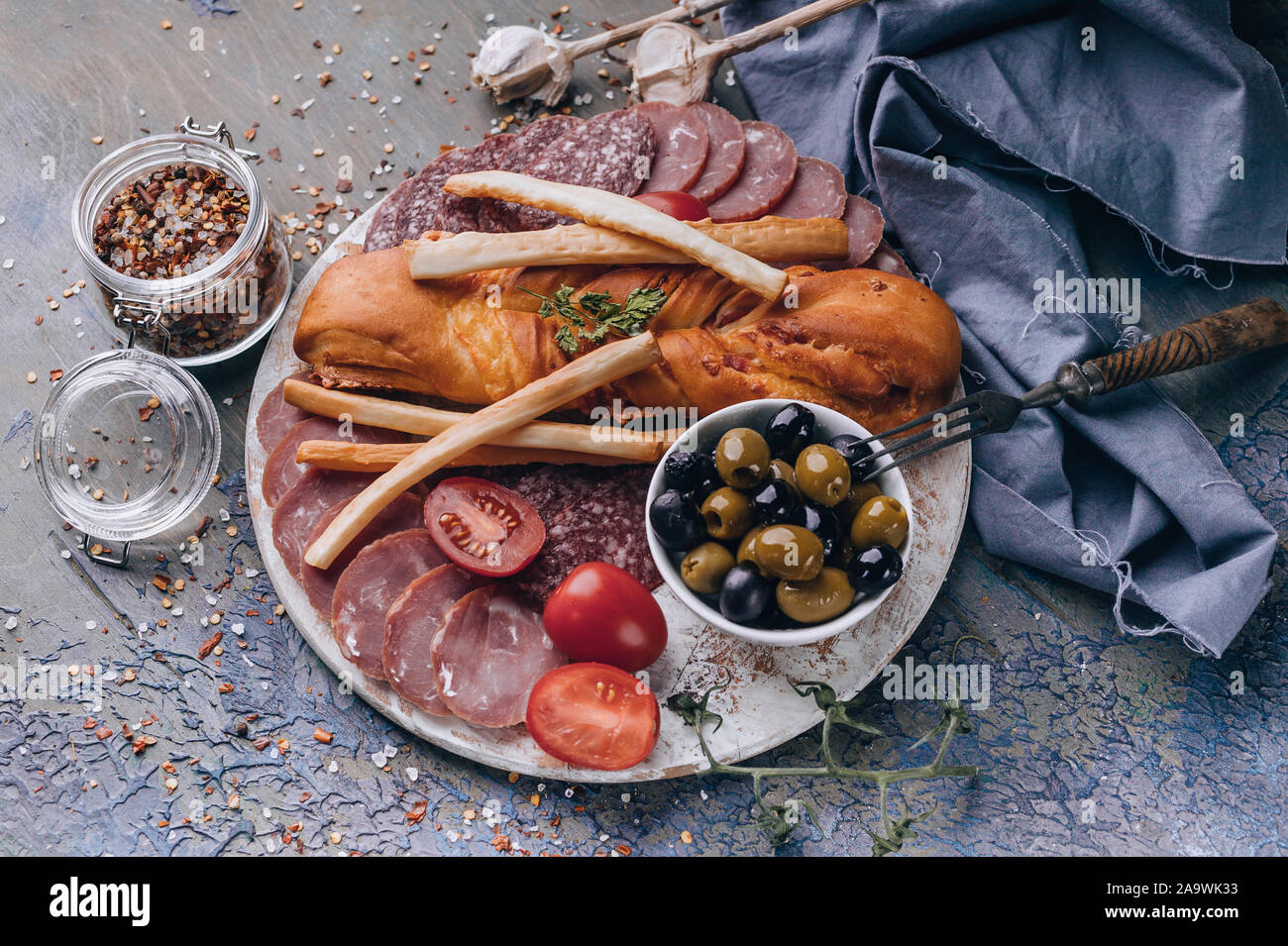 Mediterrane Speisen. Ansicht von oben sortiert aus Fleisch und Käse auf einem runden Schneidebrett. Roh geräucherter Wurst, Schinken, Käse, Oliven. Platz kopieren Stockfoto