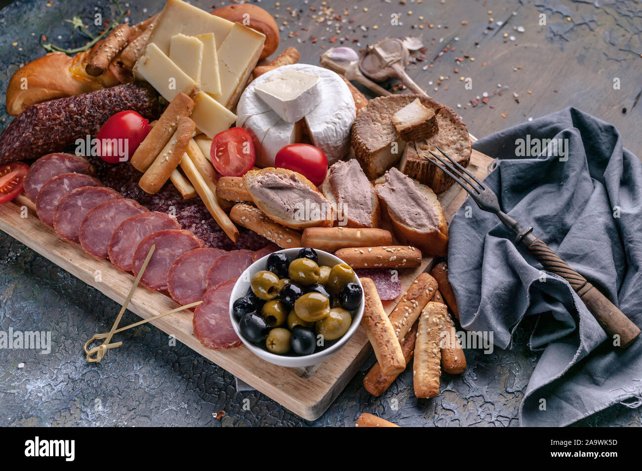 Verschiedene Käsesorten, geräucherte Fleisch- und Wurstwaren auf einem Schneidebrett. Mediterrane Speisen. Nahaufnahme Stockfoto