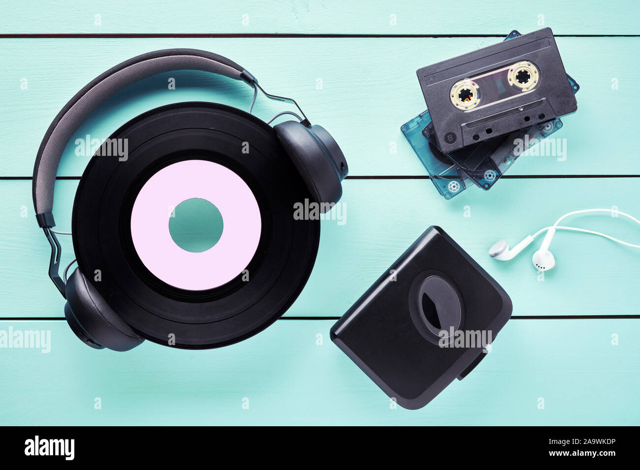 Vintage vinyl platten, Kopfhörer, Ohrhörer, Kassettenrecorder und Kassetten, auf Holztisch. Konzept der 80s Musik Gadgets. Stockfoto