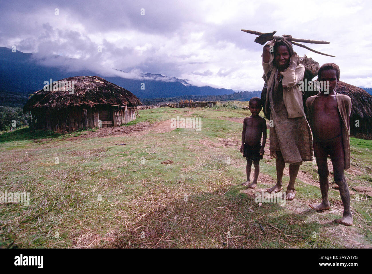 Indonesien. Irian Jaya. Dani Hill Tribe Familie in ihrem Dorf. Stockfoto