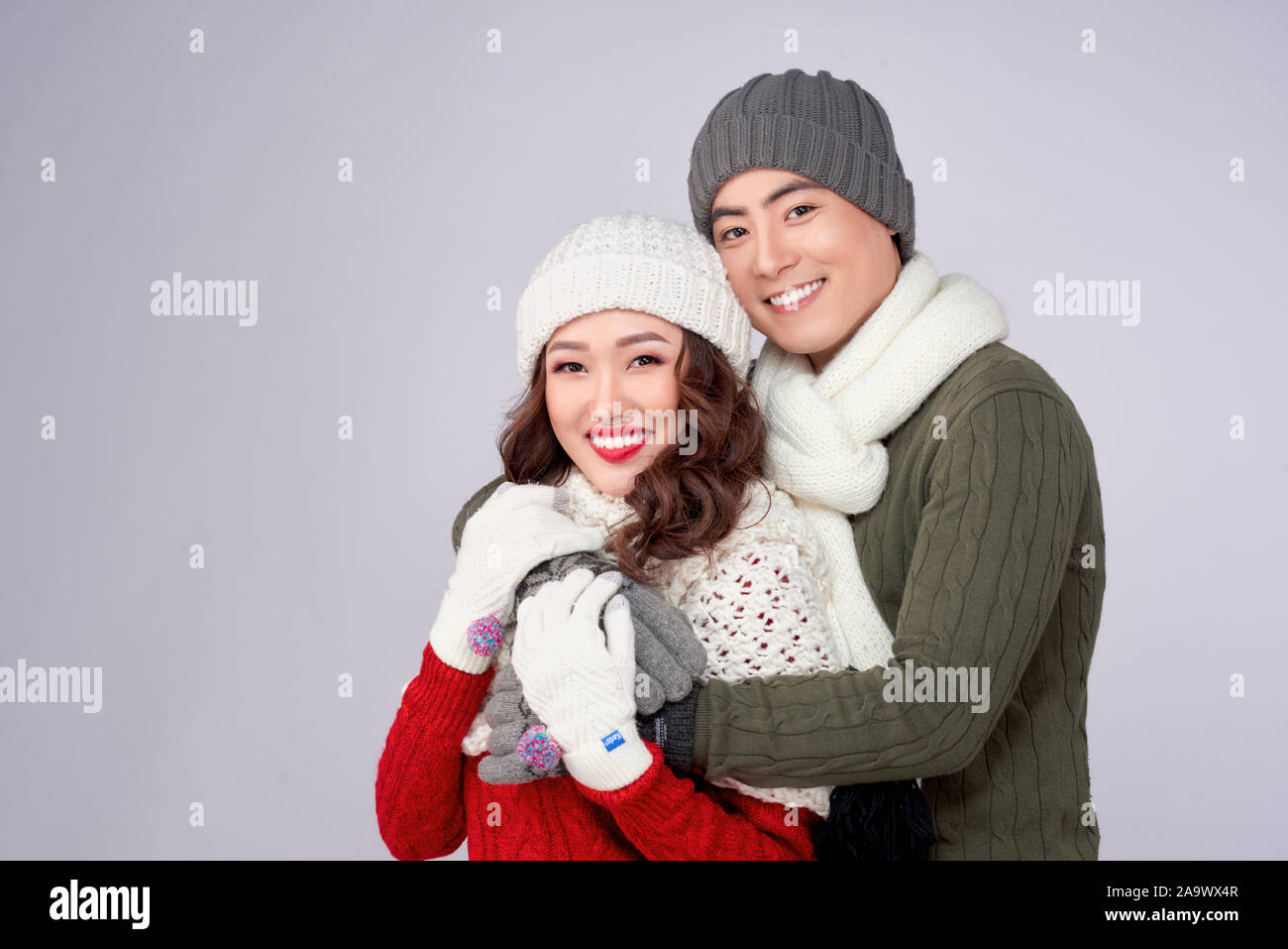 Glückliche junge Liebhaber auf gestrickte wollene Kleidung umarmen und zusammen suchen. Stockfoto