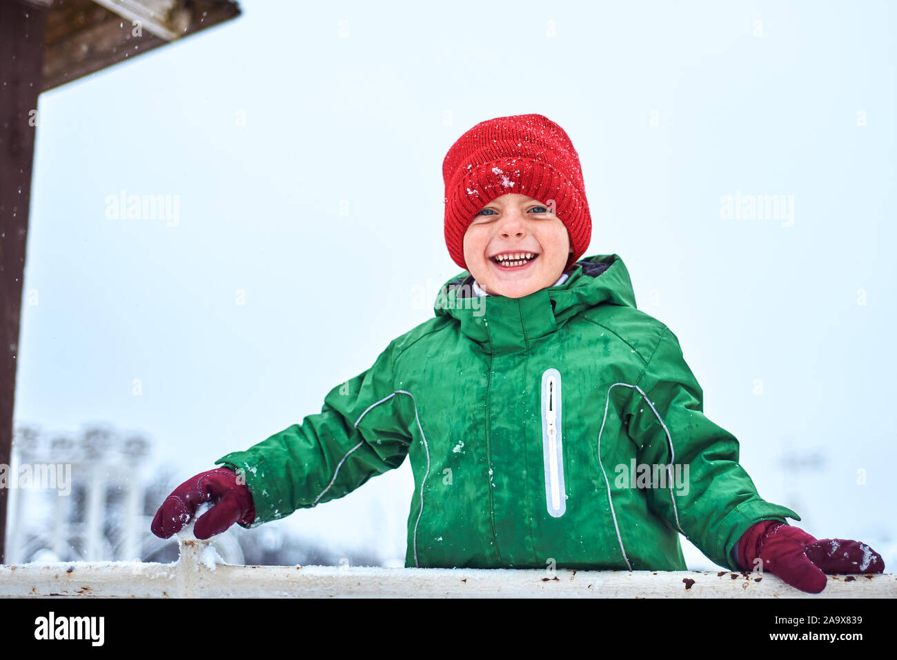 Winter Porträt eines kleinen Jungen in einem Red Hat. Kind spielt und Spaß haben auf dem Spielplatz Stockfoto